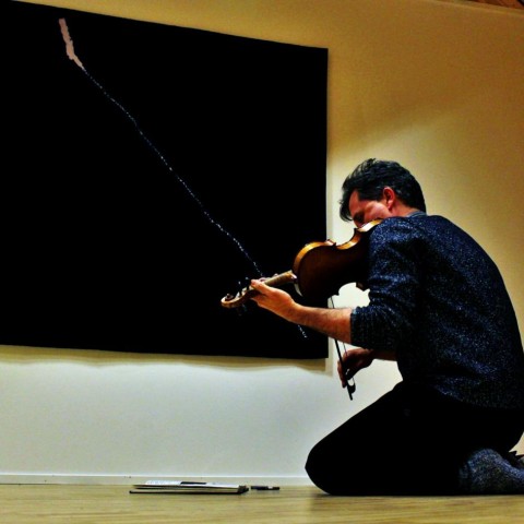 Peter Shepard Skærved works in front of Jan Groth's "Tegn V" in Kunsthall Svalbard